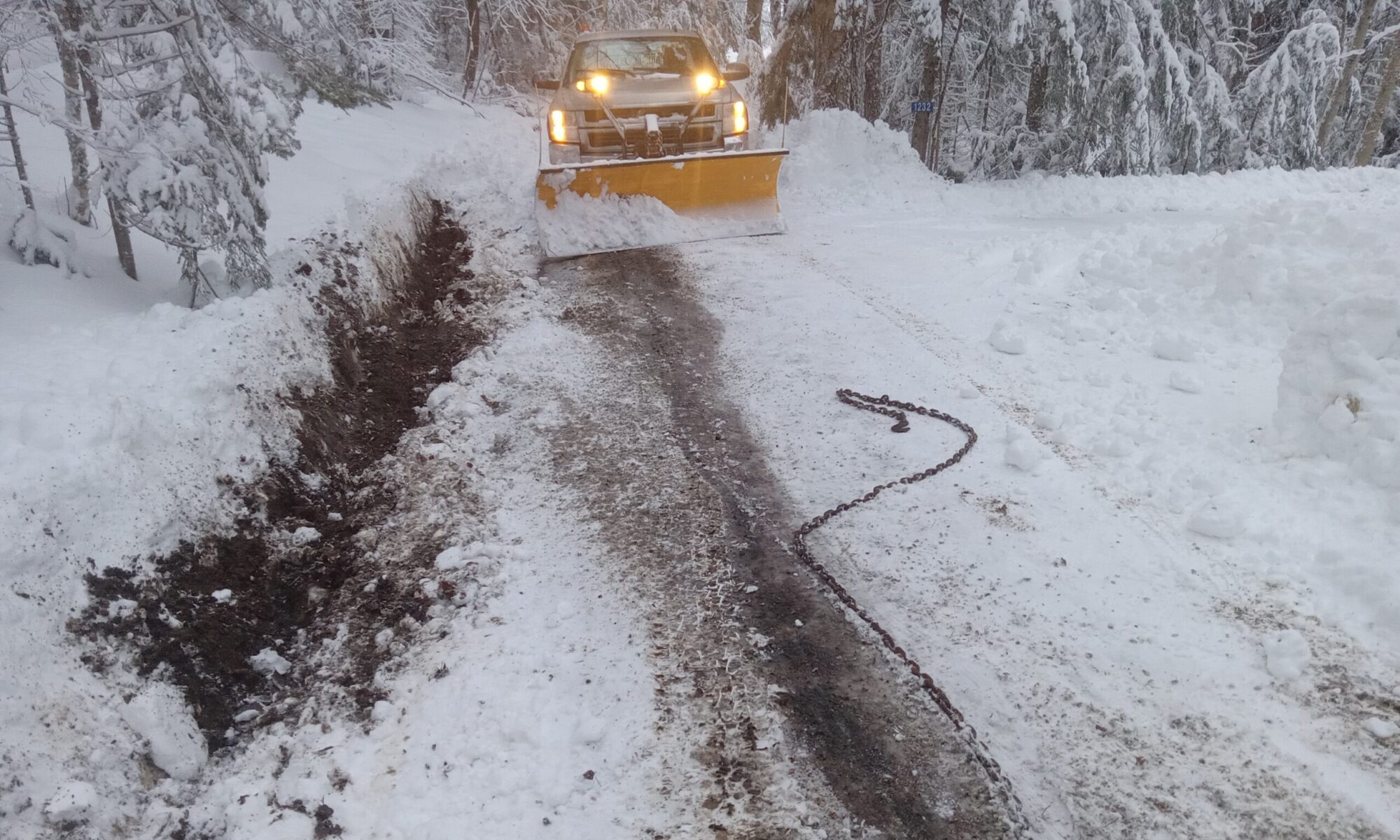 A plow truck on the road finishing snow removal